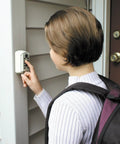 Person using AccessPoint Slimline Push Button Key Safe Lock Box With Weather Cover For Wall Mount Holds Two Keys installed on wall