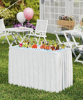 Portable Folding Ice Cooler Table With Drain And Satin Skirt Matching Foldable Bucket Bev Station in garden party setting
