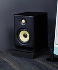 Studio Monitor Isolation Pads For 5 Inch Monitors, 2 Pack, High Density Acoustic Foam supporting a speaker beside a computer screen.