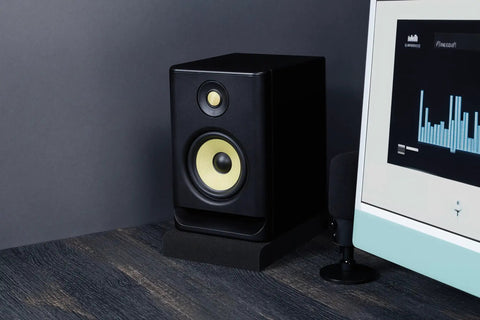 Studio Monitor Isolation Pads For 5 Inch Monitors, 2 Pack, High Density Acoustic Foam supporting a speaker beside a computer screen.