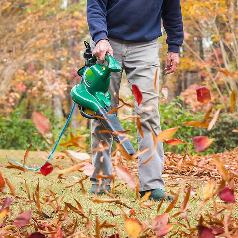 Person using a leaf blower powered by Orange 16 Gauge 3 Prong Grounded Extension Cord 100 Ft Heavy Duty Outdoor Power Cable.