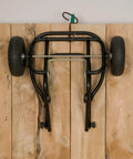 Top view of Three Pack Muck Cart Utility Wagon frame with two pneumatic tires and adjustable handle on wooden background.