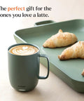 Slick App Controlled 14 Oz Smart Heated Coffee Mug With Rechargeable Base And Glow Led Display Keeps Your Joe Piping Hot From First Sip To Final Drop Certified Renewed For Daily Grind with latte art beside croissants.