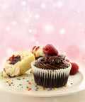 Chocolate cupcake with raspberry topping on a plate with sprinkles, showcasing decorating potential of Cupcake Injector And Decorating Icing Kit.