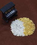 4mm Mini Metal Daisy Spacer Beads Bulk 600Pcs Silver And Gold for DIY bracelets and necklaces, shown with miniature piano, 1.5mm hole