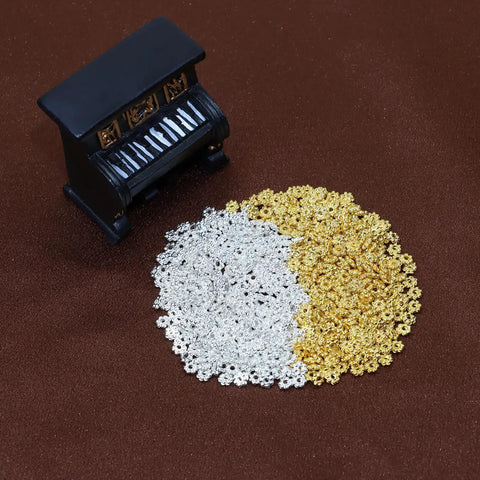 4mm Mini Metal Daisy Spacer Beads Bulk 600Pcs Silver And Gold for DIY bracelets and necklaces, shown with miniature piano, 1.5mm hole