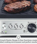 Breville Stainless Steel Electric Grill Panini Maker With One Touch Presets for burgers, cooking steaks on ceramic plates.