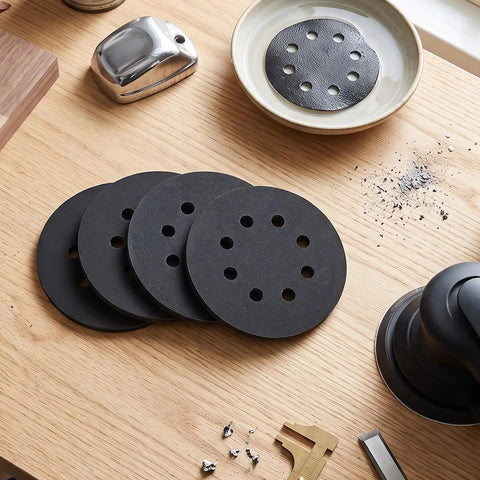 Kickstart Your Woodworking Projects With These Badass 5 Inch Silicon Carbide Sanding Discs featuring 8 quick hook loop holes on a workbench.