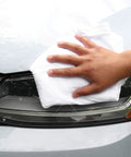 Hand using Bulk T Shirt Rags 5 Lb Box White Cotton Wiping Cloths For Paint, Stain, Grease Cleanup In Shop And Auto Use on car headlight