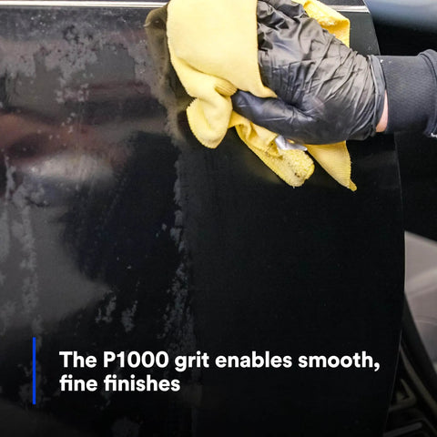 Person using a cloth on an auto body panel to finish sanding, highlighting P1000 grit for smoothing Trizact Hookit 3 Inch Blending Disc action.