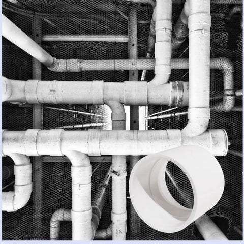 6 Inch PVC DWV Coupling for Drain Waste and Vent Sanitary Fitting in white, positioned with connected PVC pipes in a drainage system