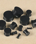 Soft Silicone Ear Gauges Set 8G To 25mm Stretching Kit For Women Men Black Flexible Plugs And Tunnels on beige background