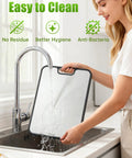 Woman cleaning Two Sided Non Toxic Cutting Board For Kitchen With Stainless Steel And BPA Free PP Surfaces 15.9 Inches Non Slip