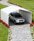 Heavy Duty Metal Garage And 20 X 30 Foot Steel Carport featuring a silver SUV parked on a stone path surrounded by flowers.