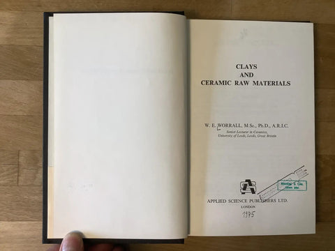 Open book showing title page of Clays And Ceramic Raw Materials Practical Guide For Potters And Ceramic Artists From 1975 With 203 Pages In English Good Condition Old School Reference Book For Clay Hobbyists And Professionals.