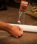 Person applying Crystal Clear Duct Tape 1.88 Inch by 9 Yard Heavy Duty All Purpose Tape on a white pipe, demonstrating easy hand tear.
