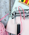 5 Pack Needle Threaders For Hand Sewing And Machine Threading Plastic Threader Tools visible with pink yarn in sewing machine setup.