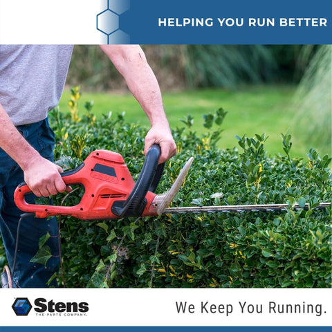 Red electric hedge trimmer cutting a dense green hedge; Stens logo visible.