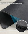 Close-up of 0.12 inch thick black mouse pad showing reinforced stitching edges and non-slip rubber base.