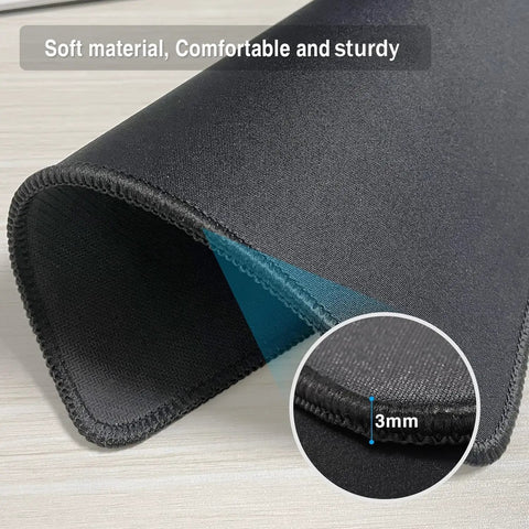 Close-up of 0.12 inch thick black mouse pad showing reinforced stitching edges and non-slip rubber base.
