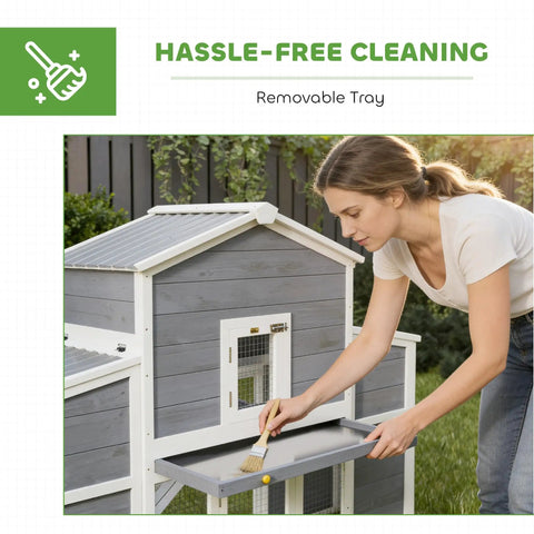 Woman demonstrating sliding tray of 66.5 Inch Large Wooden Chicken Coop With 2 Nesting Boxes, Ramp, Sliding Tray And Waterproof Roof