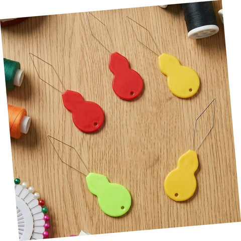 Gourd Shaped Needle Threaders 100 Pack Plastic Threading Tools For Hand Sewing And Embroidery, Effortless Threading, Versatile Use For Travel, Grab And Go DIY Crafts, And Quick Needle Tasks, multicolor plastic threaders on wood