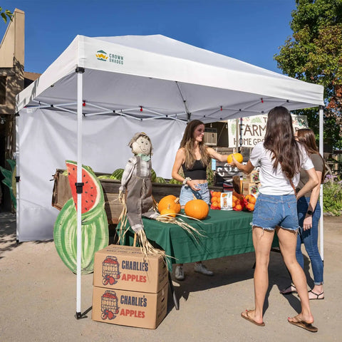 SunWall Silver Coated Sidewall For 10x10 Pop Up Canopy Tent 1 Pack Waterproof 150D Polyester With UPF50 Plus UV Protection White Ideal For Hangouts And Weatherproof Shade On Most 10x10 Straight Leg Canopies used at a farmers' market with a table of produce.