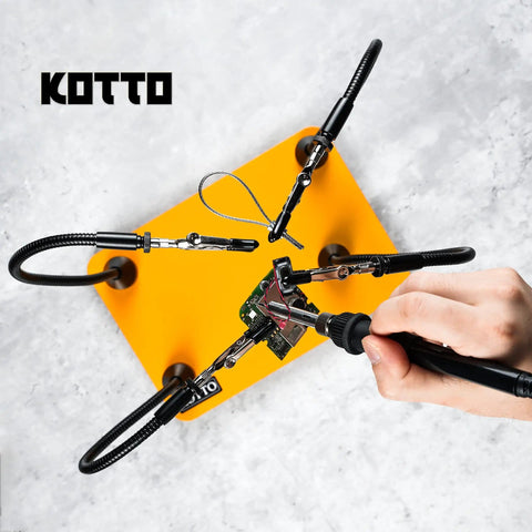 Third Hand Soldering Tool With Four Magnetic Gooseneck Arms And Stainless Clips For PCB Holder Soldering Repairs Jewelry And Crafts 360 Degree Rotation Non Slip Weighted Base Handy Helping Hands Station, shown securing a circuit board with a soldering iron in use.