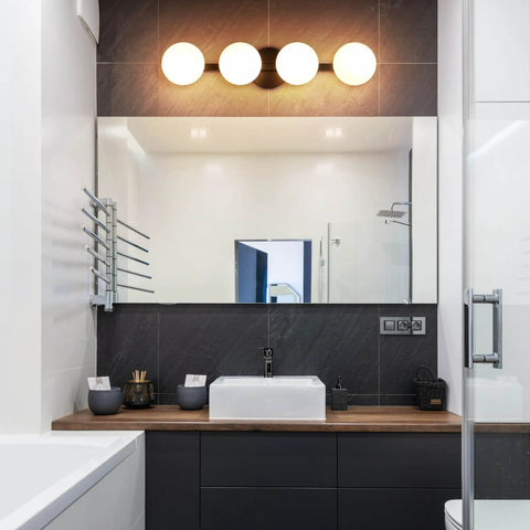 Sleek Matte Black Four Light Vanity Light Fixture With Opal Glass Globes above bathroom mirror, modern decor