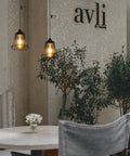 Three Pack Battery Operated Outdoor Chandelier Pendant Lights With Rustic Black Metal Bell Shade For Gazebo Patio Porch Decor, hanging near table with greenery.