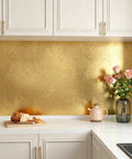 Dope Gold Peel And Stick Wallpaper Thick Metallic Wallcovering covering gold kitchen backsplash with flowers and bread.