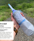Person holding the GoSpa Travel Bidet GS 70 Portable Peri Bottle with nozzle storage bag outdoors