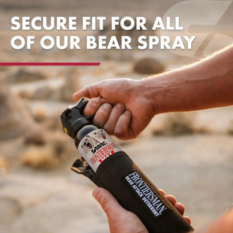 Person holding Frontiersman Max Bear Spray Kit With 7.9 Oz Deterrent, 40 Ft Range, Belt Holster in hand, outdoor setting