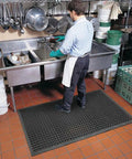 Man standing on Anti-Fatigue 3 Ft by 10 Ft Rubber Floor Mat For Commercial Kitchens With Drainage Holes Beveled Edges in kitchen