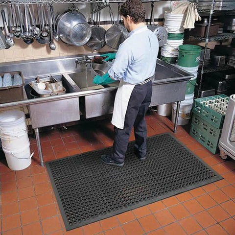 Man standing on Anti-Fatigue 3 Ft by 10 Ft Rubber Floor Mat For Commercial Kitchens With Drainage Holes Beveled Edges in kitchen