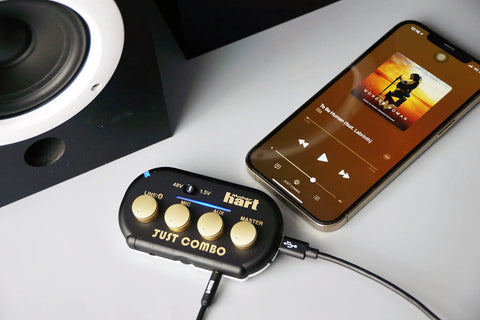 Just Combo Podcast Mini 3 Channel Audio Mixer With Stereo Bluetooth Mic Input USB Audio Out And Dual Outputs next to smartphone