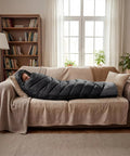 Person resting on a sofa inside Cozy Yet Lightweight 3-4 Season Sleeping Bag For Adults And Kids, 4-Pound Packable With Compression Sack