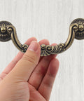 Person holding Antique Drop Bail Drawer Pulls Set Of 6 With 5 Inch Center To Center Holes And 6.4 Inch Overall Length Vintage Bronze Handle