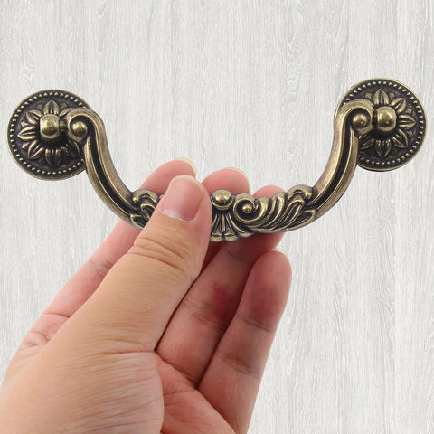 Person holding Antique Drop Bail Drawer Pulls Set Of 6 With 5 Inch Center To Center Holes And 6.4 Inch Overall Length Vintage Bronze Handle