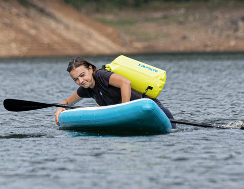 Kayaker using a Floating Waterproof Dry Bag Backpack 40L For Kayaking Rafting Boating Swimming Camping And Fishing Roll Top Sack in bright yellow.