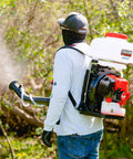 Person using 3HP Backpack Mosquito Fogger And Garden Sprayer With 3.7 Gallon Tank for liquid pesticides in a garden setting