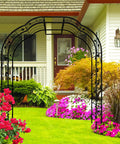 Tall Black Garden Arch Trellis 8.2 Ft High 6.2 Ft Wide Outdoor Arbor For Climbing Plants Roses And Vines in a garden setting