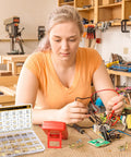 Woman assembling components with 480 Pcs M2 M2 5 M3 Motherboard Standoffs And Screws And Nuts Kit with brass spacers.