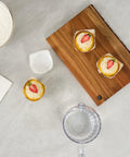 Flat lay of Greaseproof Cupcake Liners 4000 Pack, 4 Oz Disposable Muffin Cups on a wooden board, some filled with cupcakes.