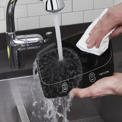 Waterproof Digital Kitchen Scale With 11 Pound Capacity Pro Grade Precision Ultra Accurate being rinsed under faucet