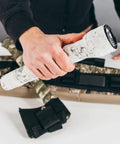 Hand holding flashlight wrapped in Self Cling Camouflage Fabric Wrap For Gear And Knives, Reusable And Washable, 2 Inch By 144 Inch
