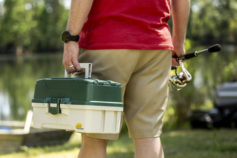 Person carrying 3-Tray Tackle Box With Dual Top Access Dark Green Metallic And Off White Premium Tackle Storage for anglers.