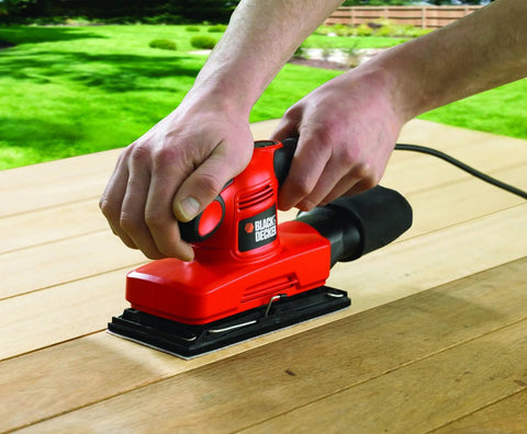 Badass Compact Electric Orbital Sander With Rugged Ergonomic Design And Turbo Spin Action in use on a wooden surface.