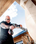 Premium 18V Brushless Cordless Hammer Drill Driver Featuring A Beefy Half Inch Quick Swap Chuck And Smart Torque Control To Rattle Off Stripped Bolts Like A Boss While Crushing Concrete Tasks Tool Only in use on wooden beam.