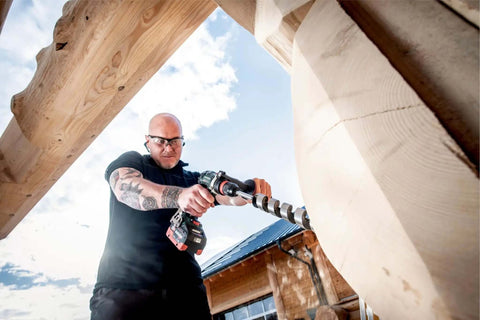 Premium 18V Brushless Cordless Hammer Drill Driver Featuring A Beefy Half Inch Quick Swap Chuck And Smart Torque Control To Rattle Off Stripped Bolts Like A Boss While Crushing Concrete Tasks Tool Only in use on wooden beam.